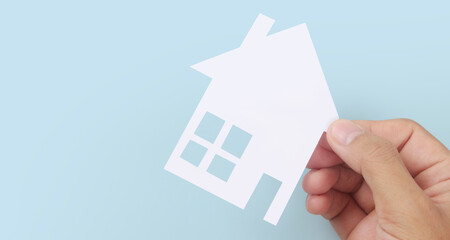 Hands holding paper house, family home protecting insurance concept
