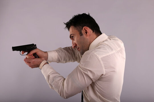 a man in a jacket aiming a gun