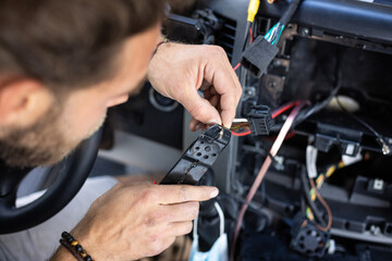 Man working on electronics inside a car