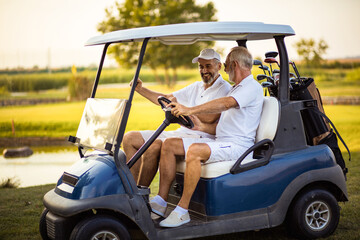 Two older friends are riding in a golf cart. - 435773313
