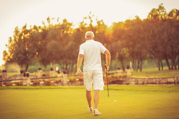 Senior golfer playing golf on court.