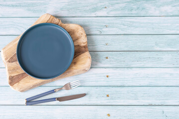 Blue table setting over wood background with cutlery. copy space