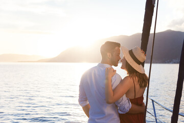 Young couple in love traveling on yacht. Happy travelers relaxing and enjoying summer vacation by...