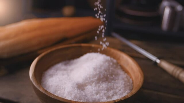 Chef takes salt for the dish, cooking in slow motion, falling liquid in 240 frames per second, cooking food side view