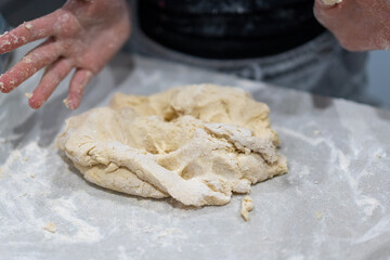 hands kneading dough on marble kitchen bench, baking cinnamon rolls from scratch