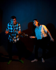 Fototapeta premium A guy in a plaid shirt and a girl with a dust brush against a dark background