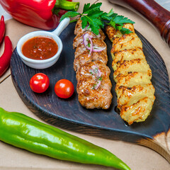 Beef And Potato Kebabs With Hot Sauce On The Black Wooden Tray