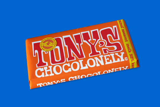 Tony's Chocolonely, Tenerife, Canary Islands, Spain - March 21, 2021: one caramel and sea salt chocolate bar on a blue surface, confectionary produced and sold by the Dutch company Tony's Chocolonely
