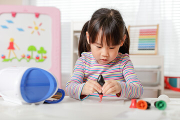 young girl making 3D shape craft for homeschooling