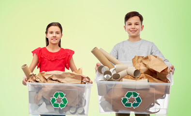 recycling, waste sorting and sustainability concept - smiling girl and boy with paper garbage in plastic box over green background