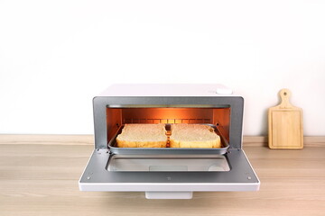 white modern design toaster oven is on the wooden table with white cement wall background in...