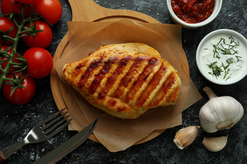 Concept of tasty eating with grilled chicken on black smokey background