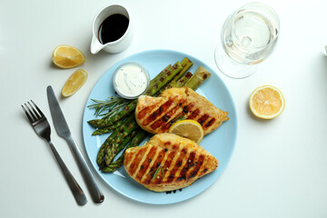 Concept of tasty lunch with grilled chicken and asparagus on white background