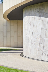 Architecture, minimalistic building design, Art Nouveau style. The gray geometry of the walls is combined with the sun and grass