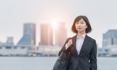 都市の前に立つビジネスウーマン 