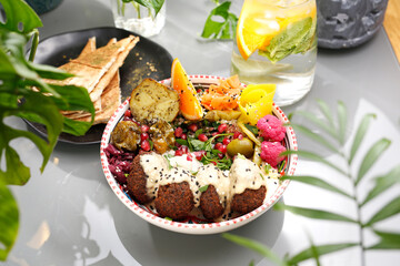 Falafel in yoghurt sauce with fruit and vegetables. Vegetarian cooking. Vegetarian fast food.
A colorful appetizing dish. Culinary photography, food styling.