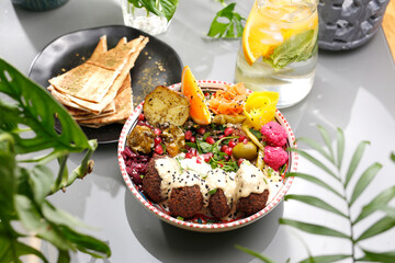 Falafel in yoghurt sauce with fruit and vegetables. Vegetarian cooking. Vegetarian fast food.
A colorful appetizing dish. Culinary photography, food styling.