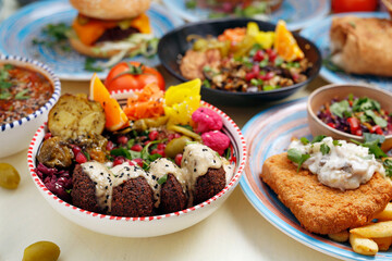 Falafel in yoghurt sauce with fruit and vegetables. Vegetarian cooking. Vegetarian fast food.
A colorful appetizing dish. Culinary photography, food styling.