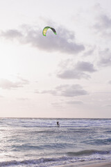 kitesurfers in the sky in the evening duck over the blue water of mediterranean sea