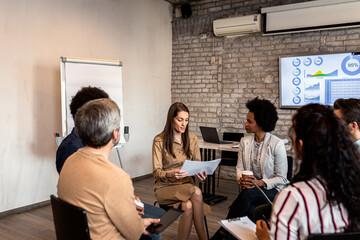 Group of diverse group of business people having a meeting while sitting in circle.