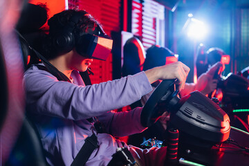 teenage boy in vr headset playing racing game on car simulator - obrazy, fototapety, plakaty