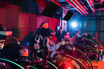 Obraz na płótnie Canvas teenagers in vr headsets playing racing game in car simulators