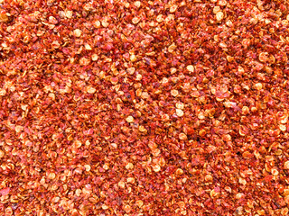 red chilli pepper flakes background texture
