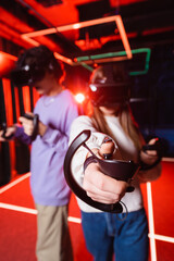 Fototapeta na wymiar blurred teenagers in vr headsets gaming in play zone