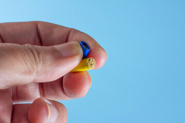 Antibiotic powder in the capsule in hand isolated on a blue background.