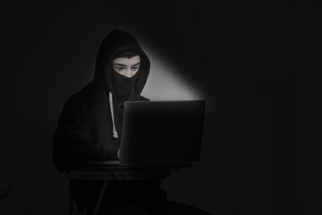Anonymous hacker with stealing data from laptop. Cyber security concept.