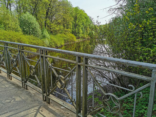 Figure fence of the bridge over the canal on a sunny spring day in the park on Elagin Island in St. Petersburg.