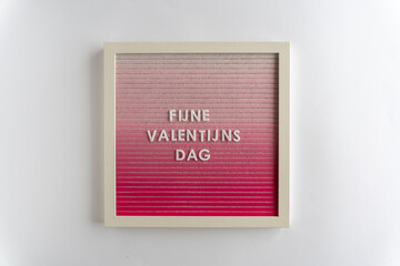 Pink Board Words That Spell Fijne Valentijn's Dag (translation: Happy Valentine's Day), on a white background, horizontal