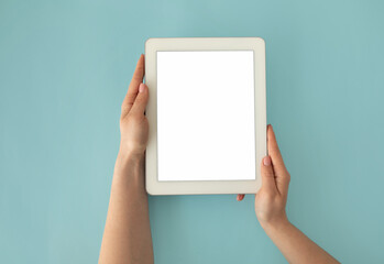 Woman holding digital tablet with empty screen for your design, website or advertisement, blue...