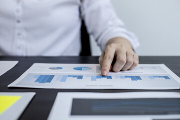 Close-up pressing a white calculator, a female auditor using a calculator to verify the accuracy of...
