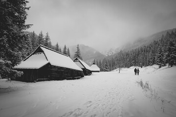 Monochrome mountain shelter view and tourists hiking on a trail in Dolina Jaworzynki, Western Tatra Mountains, Poland. Selective focus on people, blurred background.
