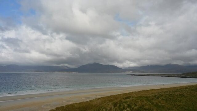 4k dramatic timelapse of cloud and sunlight movement over Luskentyre Beach, Isle of Harris, Outer Hebrides, Scotland. Dunes, white sand, turquoise sea, mountains.