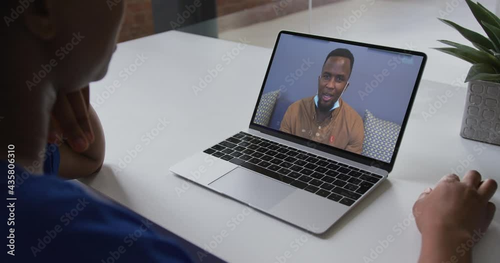 Poster Mid section of african american woman having a video call on laptop with male colleague at office