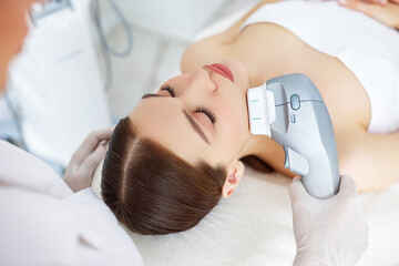 Woman getting facial lifting therapy in beauty salon