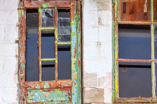 Broken wooden door and window of abandoned house