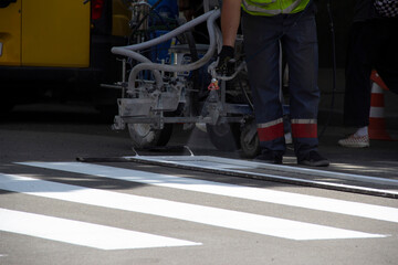 Worker applies road markings, markings for cars