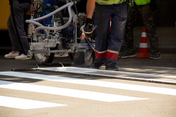 Worker applies road markings, markings for cars