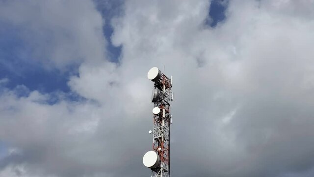 Phone broadcasting communication antenna tower over cloudy blue sky,electromagnetic waves pollution