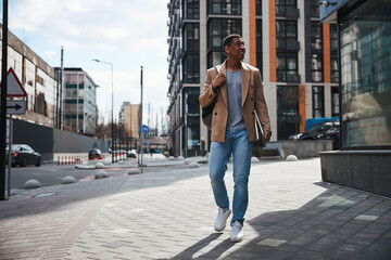 Relaxed young man walking down the street