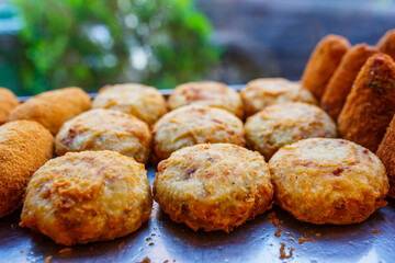 Frittatine di pasta, crocchè di patate e arancini di riso in esposizione in una vetrina di una pizzeria