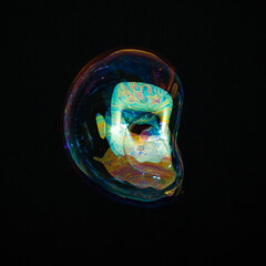 Amorphous and colorful isolated soap bubble with black background.