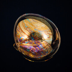 Amorphous and colorful isolated soap bubble with black background.