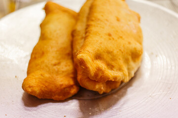 Pizze fritte napoletane ripiene di salame e ricotta appena cotte e pronte per essere vendute