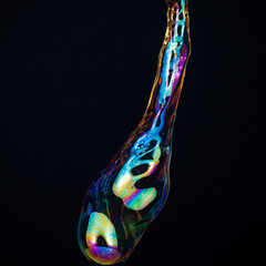 Amorphous and colorful isolated soap bubble with black background.