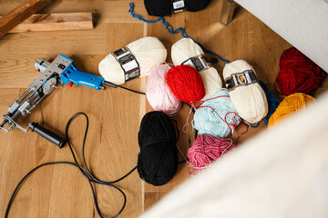 Photo of sewing machine and threads on wooden floor