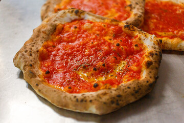 Pizze napoletane con sugo di pomodoro pronte per essere messe in vetrina